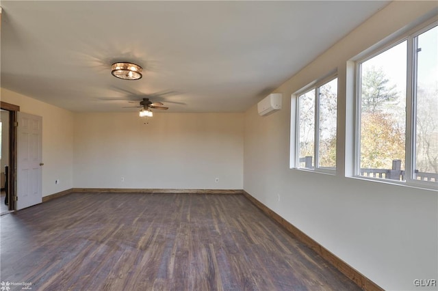 empty room featuring dark hardwood / wood-style flooring, a wall unit AC, and ceiling fan