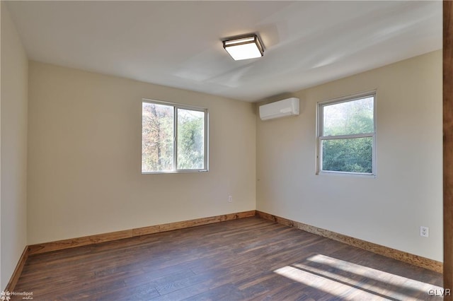 empty room with a wall mounted AC and dark hardwood / wood-style flooring