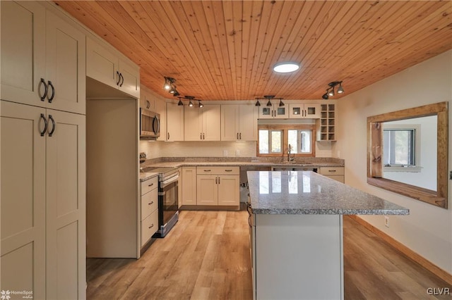 kitchen featuring white cabinets, rail lighting, a kitchen island, light hardwood / wood-style floors, and stainless steel appliances