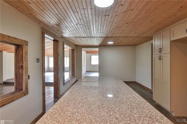 hall with dark wood-type flooring and wooden ceiling