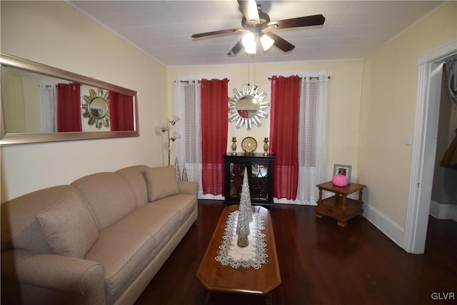 living room with crown molding, ceiling fan, and dark wood-type flooring