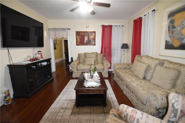 living room featuring ornamental molding, ceiling fan, and dark wood-type flooring