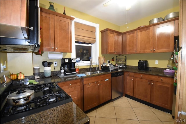 kitchen featuring dark stone counters, black stove, sink, stainless steel dishwasher, and light tile patterned floors