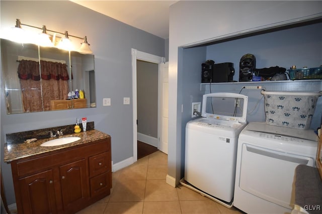 washroom with sink, light tile patterned floors, and independent washer and dryer