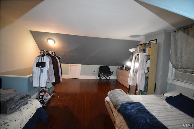 bedroom with cooling unit, dark wood-type flooring, and vaulted ceiling