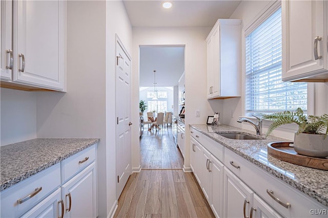 kitchen with white cabinets, light hardwood / wood-style floors, and a wealth of natural light