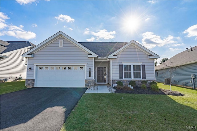 view of front facade with a garage, a front yard, and central AC