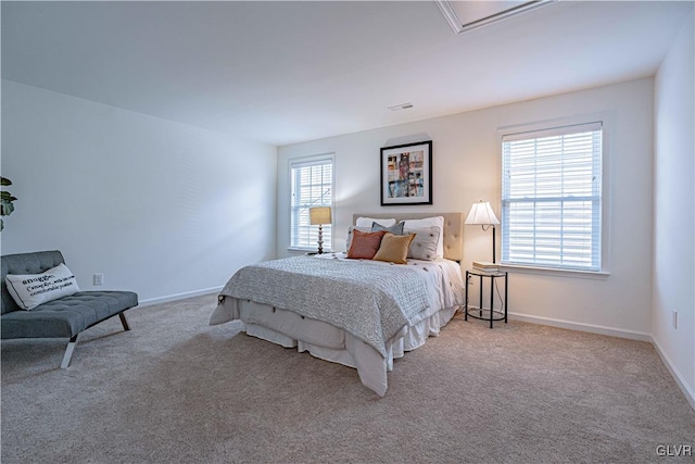 bedroom with multiple windows and light carpet