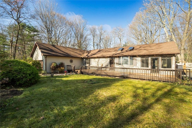 back of house featuring a lawn and a deck