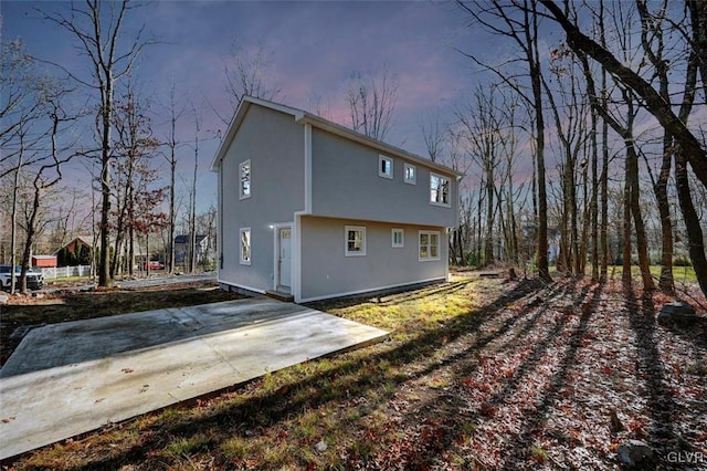 back house at dusk with a patio