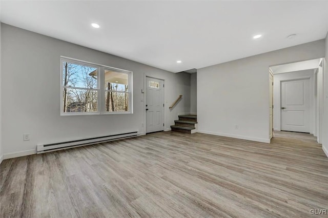 unfurnished living room with light hardwood / wood-style flooring and a baseboard heating unit