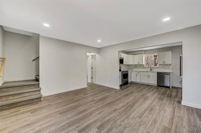 unfurnished living room with light hardwood / wood-style flooring and sink