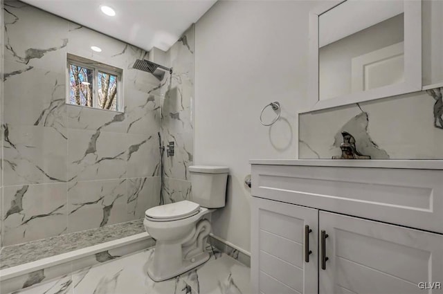 bathroom with toilet, vanity, and tiled shower