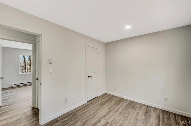 unfurnished bedroom with light wood-type flooring and a baseboard radiator