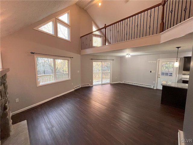 unfurnished living room with dark wood-type flooring, a fireplace, high vaulted ceiling, and a baseboard radiator