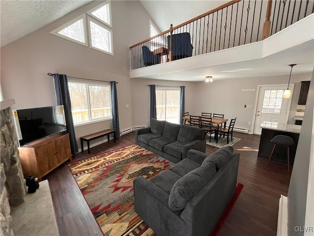 living room with high vaulted ceiling, dark wood-type flooring, a textured ceiling, and a baseboard heating unit