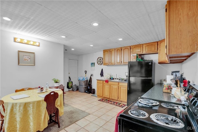 kitchen featuring light tile patterned flooring, sink, and black appliances