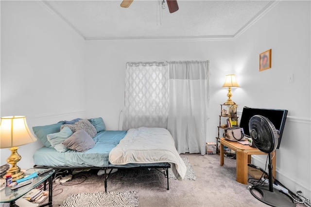 carpeted bedroom featuring a textured ceiling, ceiling fan, and ornamental molding