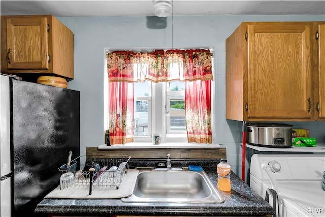 kitchen with decorative backsplash, sink, and refrigerator