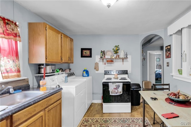 clothes washing area featuring light hardwood / wood-style floors, washing machine and dryer, and sink