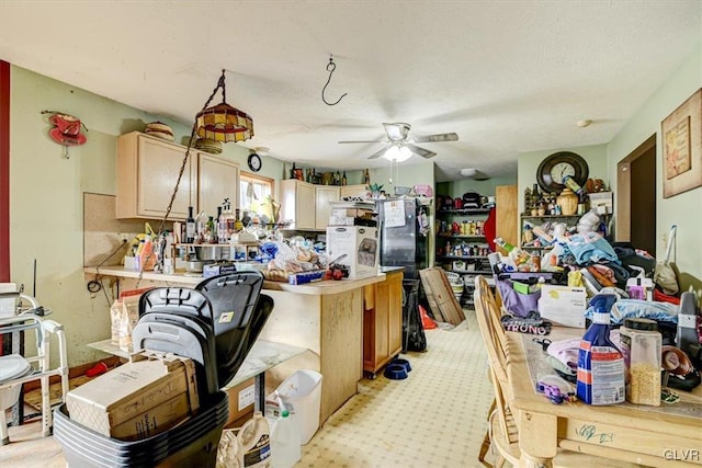 kitchen with kitchen peninsula, ceiling fan, light brown cabinets, and a textured ceiling