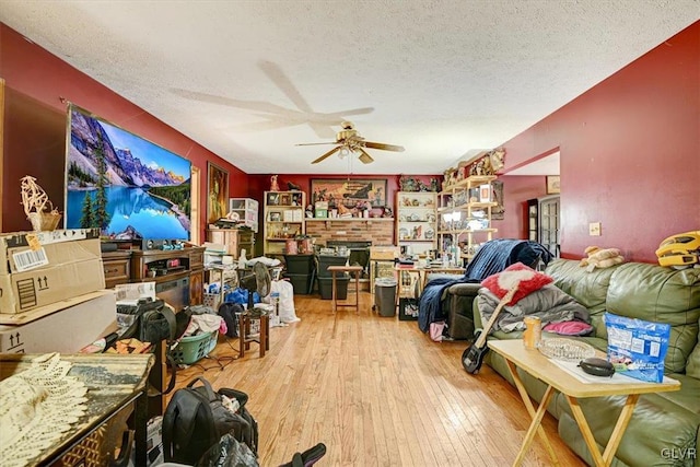 miscellaneous room featuring ceiling fan, light hardwood / wood-style floors, and a textured ceiling