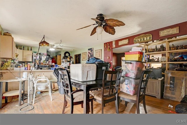 dining area with a textured ceiling and light hardwood / wood-style flooring