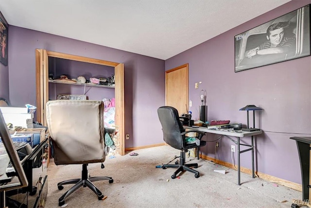 carpeted home office featuring a textured ceiling