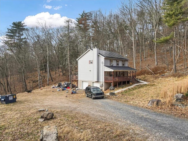 view of side of property with a garage and a wooden deck