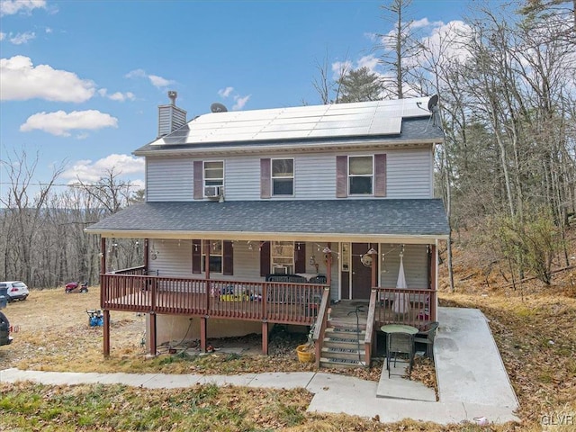 view of front of home featuring solar panels and a porch