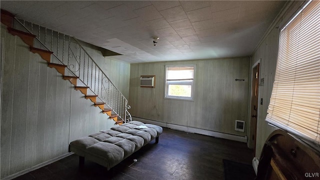 entryway with wood walls, baseboard heating, and a wall unit AC