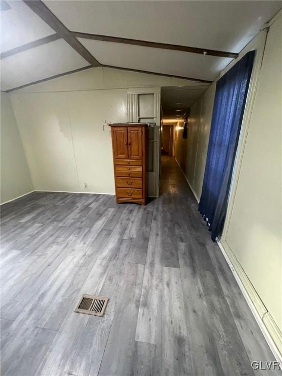 hallway with dark hardwood / wood-style flooring and lofted ceiling with beams