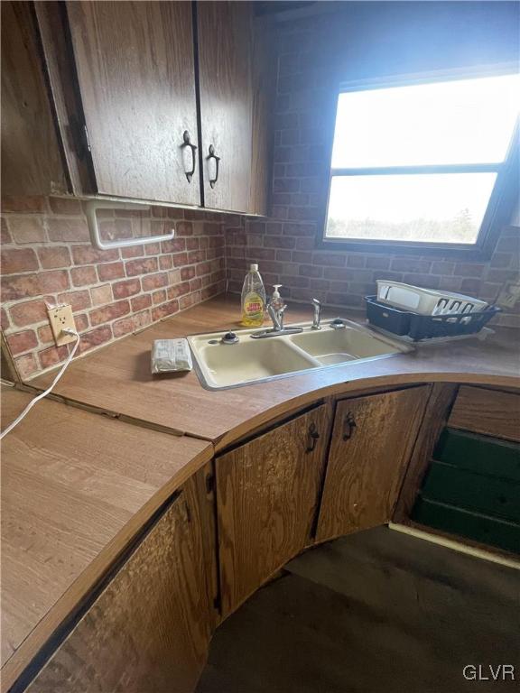 kitchen with decorative backsplash, dark wood-type flooring, and sink