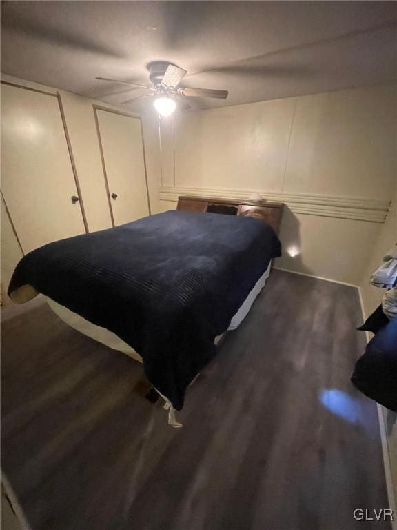 bedroom with dark hardwood / wood-style flooring and ceiling fan