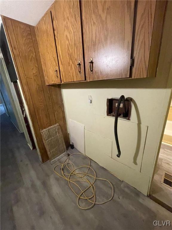 clothes washing area with cabinets, hookup for a washing machine, and hardwood / wood-style floors