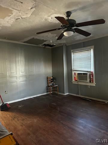 empty room featuring hardwood / wood-style floors, ceiling fan, and cooling unit