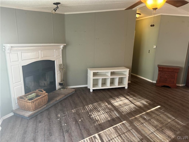 unfurnished living room featuring ceiling fan, dark hardwood / wood-style flooring, a textured ceiling, and ornamental molding