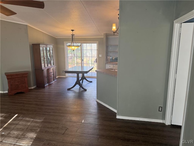 unfurnished dining area with dark wood-type flooring, crown molding, vaulted ceiling, ceiling fan, and a textured ceiling