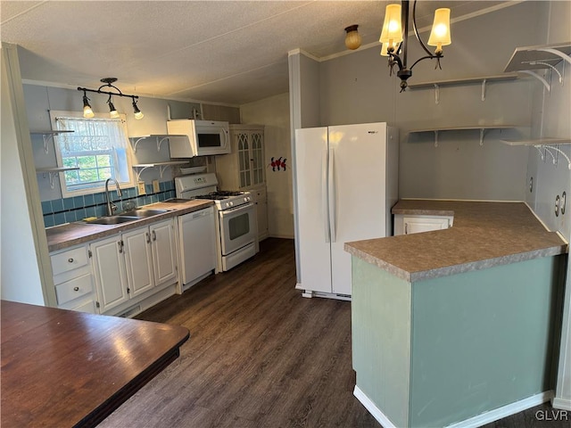 kitchen featuring white appliances, sink, dark hardwood / wood-style floors, decorative light fixtures, and white cabinetry