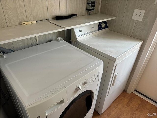 laundry area with light hardwood / wood-style flooring and washer and clothes dryer