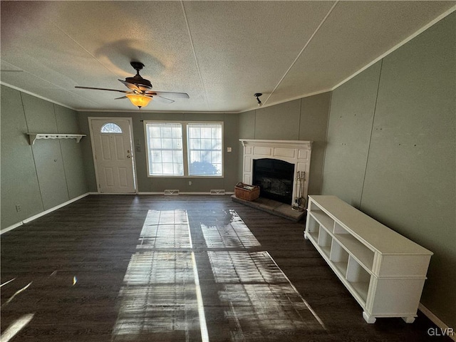 unfurnished living room with ceiling fan, dark hardwood / wood-style floors, crown molding, a textured ceiling, and vaulted ceiling