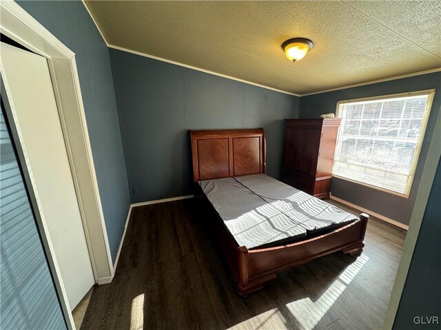 unfurnished bedroom with a textured ceiling, crown molding, and dark wood-type flooring