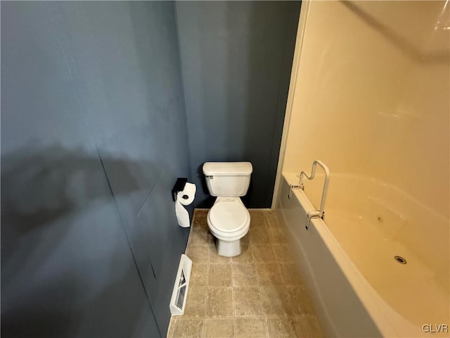 bathroom featuring a washtub and toilet