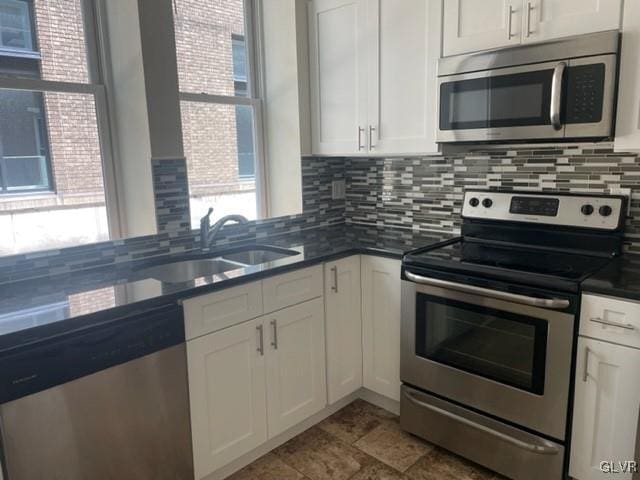 kitchen featuring stainless steel appliances, white cabinetry, and sink