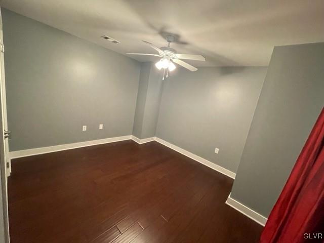 unfurnished room with ceiling fan and dark hardwood / wood-style floors