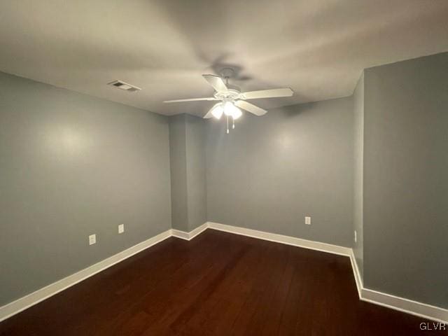 empty room with ceiling fan and dark hardwood / wood-style flooring