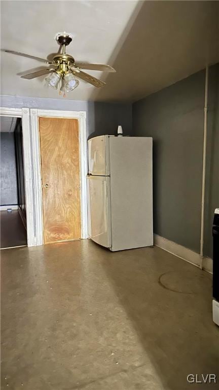 interior space featuring concrete floors, white fridge, and ceiling fan