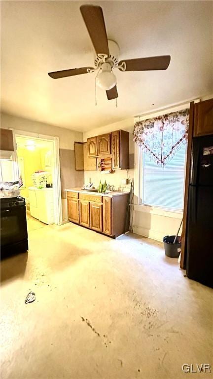 kitchen with washing machine and dryer and black appliances