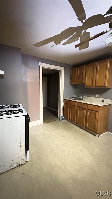 kitchen with ceiling fan, sink, and white stove