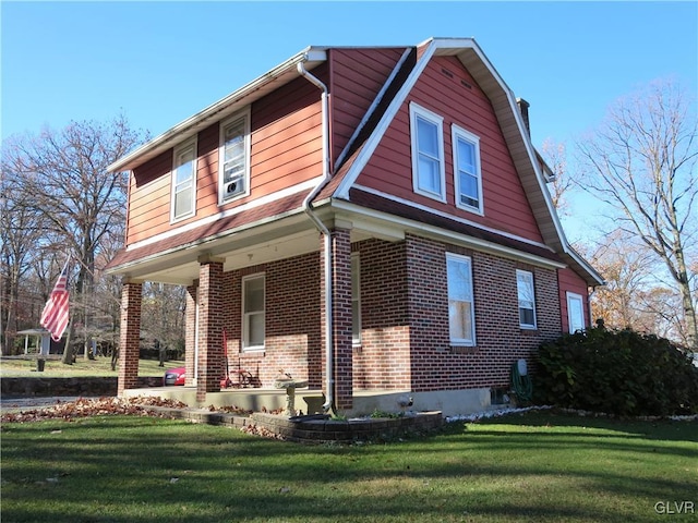 view of side of home featuring a yard and covered porch